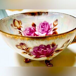 Beautiful vintage floral tea cup with handle and legs.
